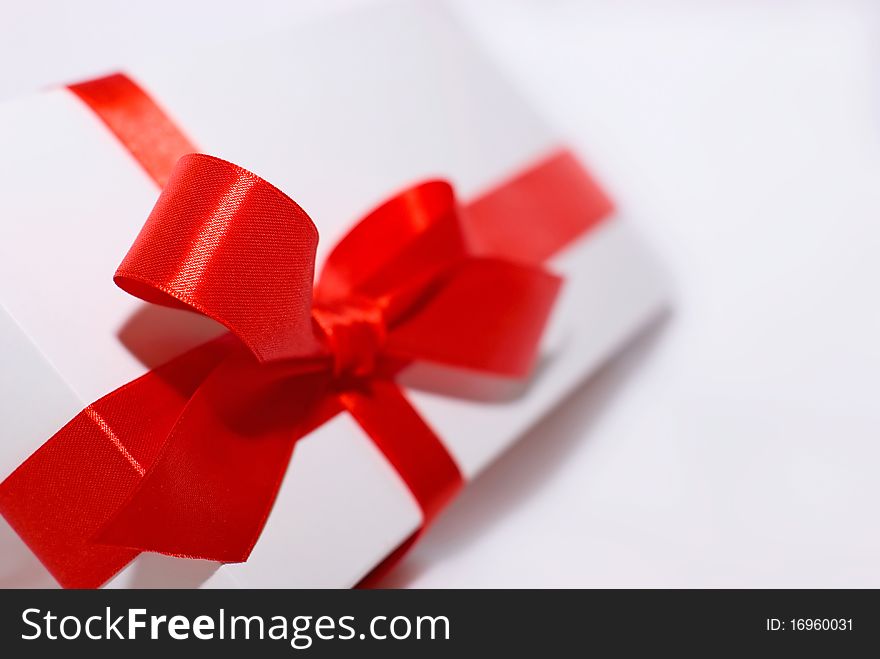 White box with red ribbon on white background. White box with red ribbon on white background