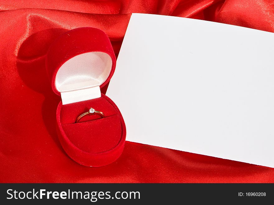 Golden ring in jewerly  box  and empty card on red satin. Golden ring in jewerly  box  and empty card on red satin