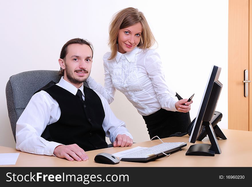 A young business man and a girl running on the computer in the office.