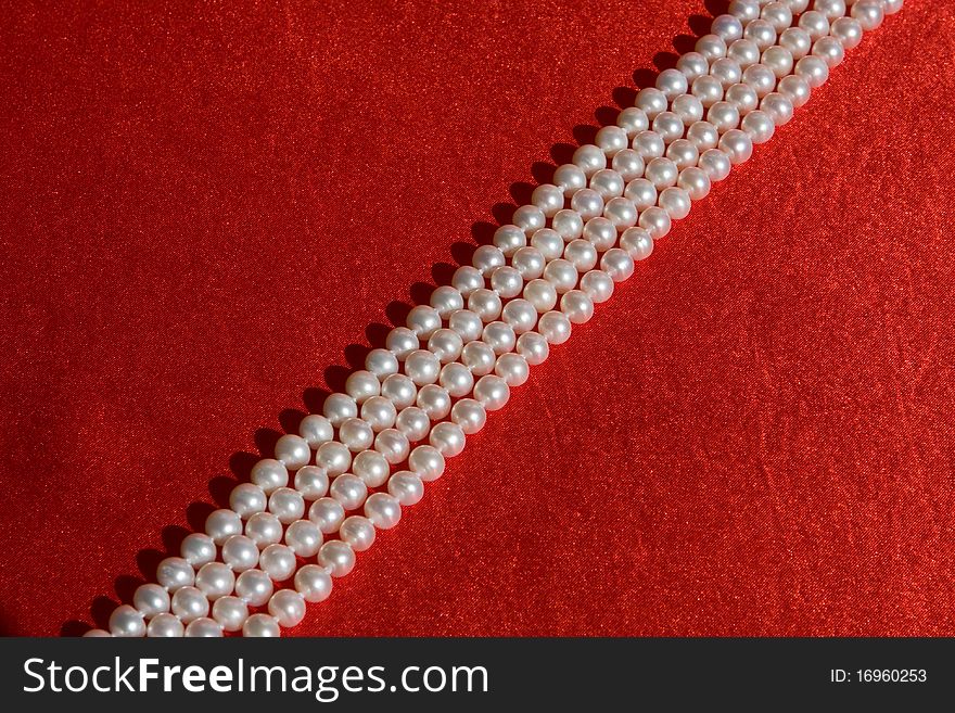 Luxury white Pearl's necklace on red background. Luxury white Pearl's necklace on red background