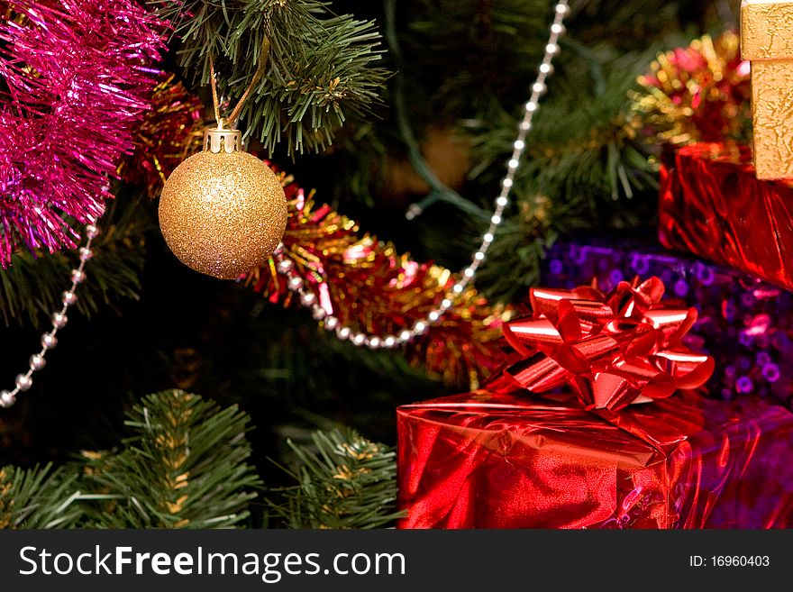 Christmas tree with gold ornament ball, close up