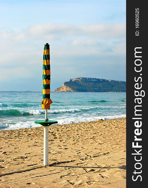 A closed sun umbrella at the end of the summer season in Cagliari, Sardinia (Italy). A closed sun umbrella at the end of the summer season in Cagliari, Sardinia (Italy)