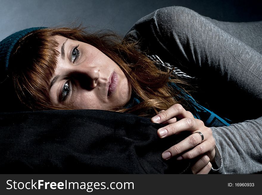 Beautiful girl with scarf, hat and bag on a black background