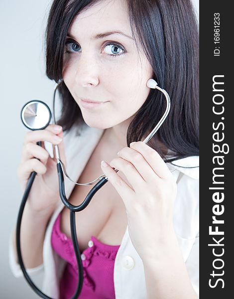 Very pretty young doctor with stethoscope (shallow DOF, selective focus; color toned image)