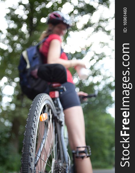 Pretty young female biker outddors on her mountain bike (shallow DOF; selective focus). Pretty young female biker outddors on her mountain bike (shallow DOF; selective focus)