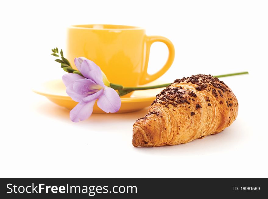 Croissant, cup of coffee and flower