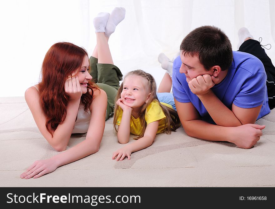 Young mother, a young father and young daughter have fun together