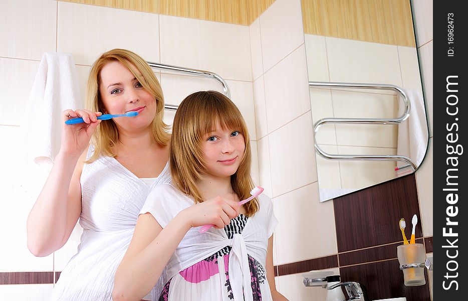 A young girl and her mother woke up early in the morning brushing his teeth in his bathroom