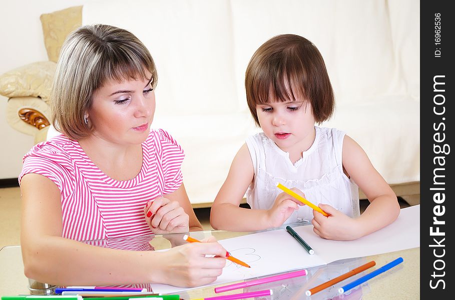 Mother and daughter together paint an album and have fun together.