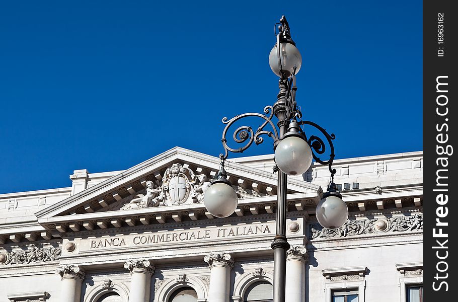 Ornate street lamp in front of bank building in Milan. Ornate street lamp in front of bank building in Milan.