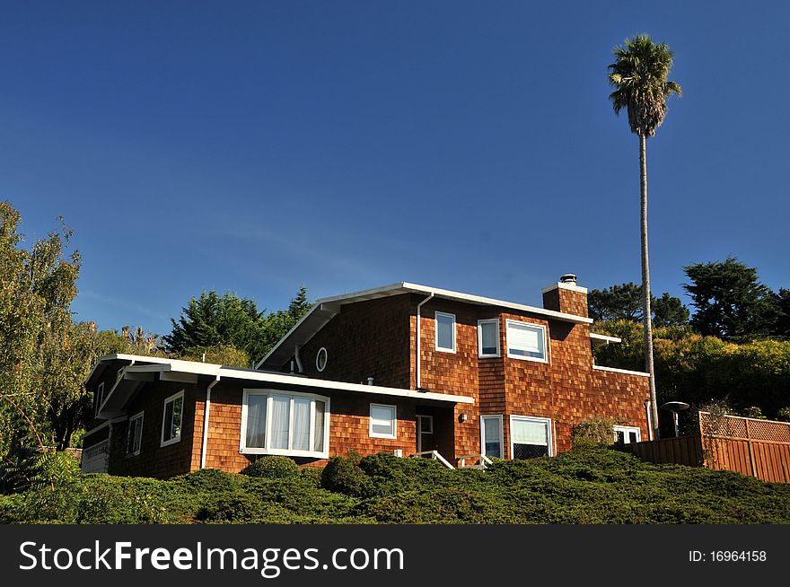 House with two garages on a hill with sky. House with two garages on a hill with sky