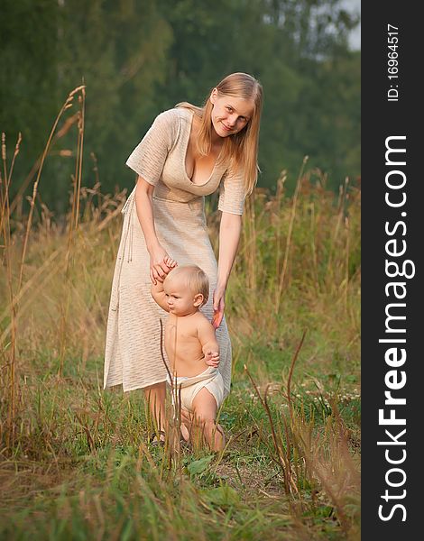 Mother walk with baby  in park on sunset