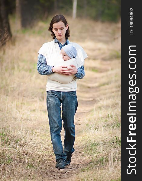 Father walking with daughter in sling.