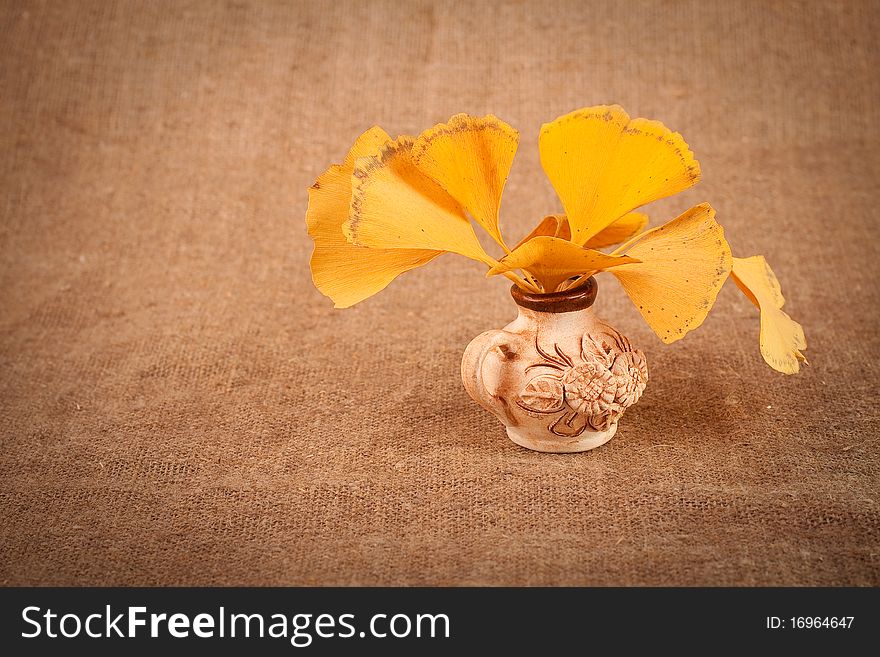 Jug with leaves on sacking