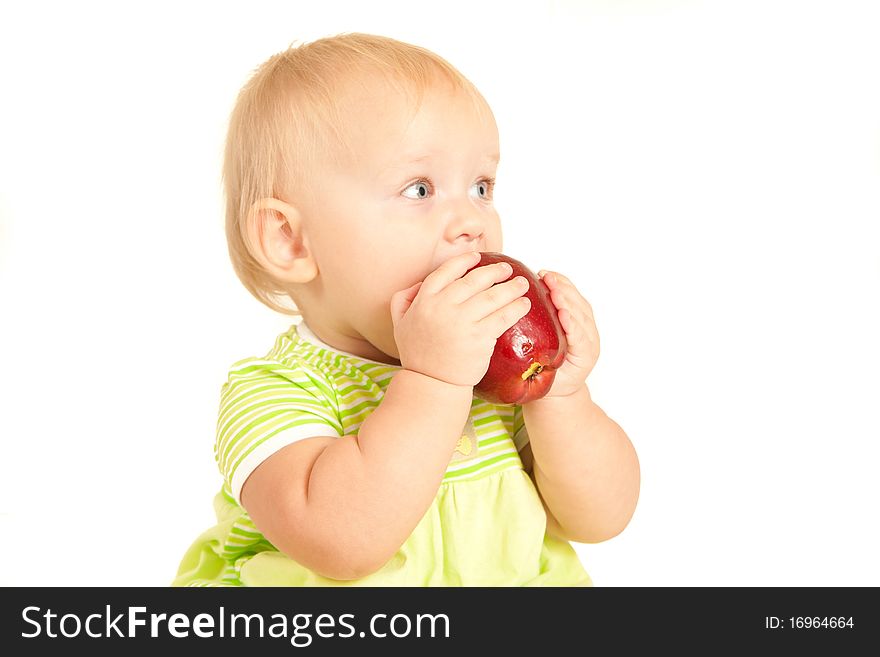 Young little baby eat red apple on white