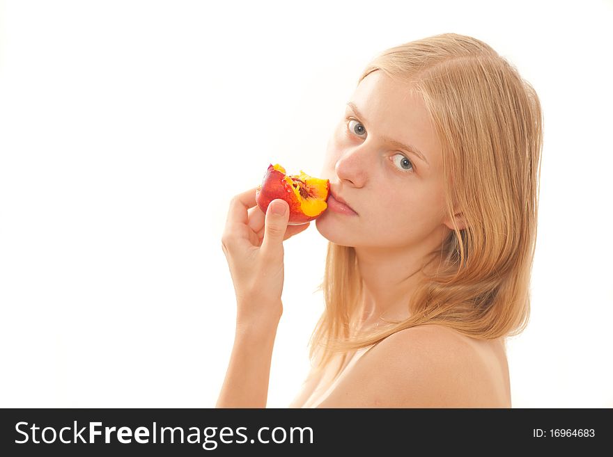 Beautiful young girl eating a peach on white. Beautiful young girl eating a peach on white