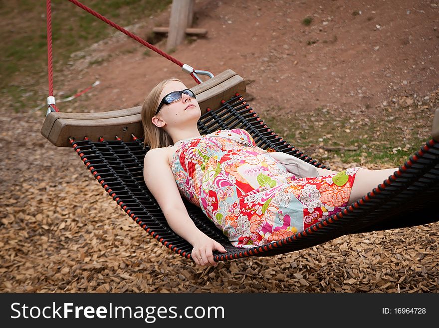 Young beutiful pregnant woman relaxing in hammock in park