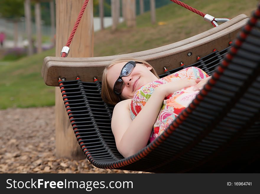 Beautiful Woman Relaxing In Hammock In Park