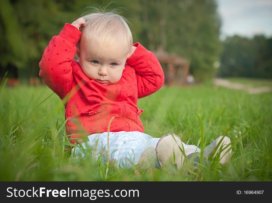 Baby Sit On Green Grass In Park