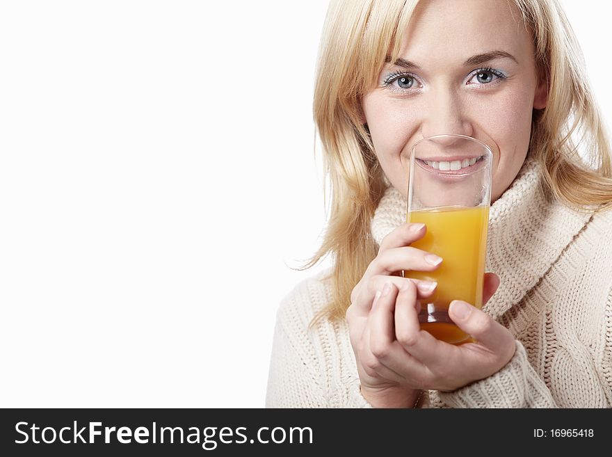 A woman in a sweater drinking juice on a white background. A woman in a sweater drinking juice on a white background
