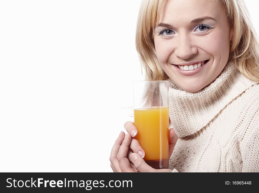 A woman in a sweater with a glass of juice on a white background. A woman in a sweater with a glass of juice on a white background
