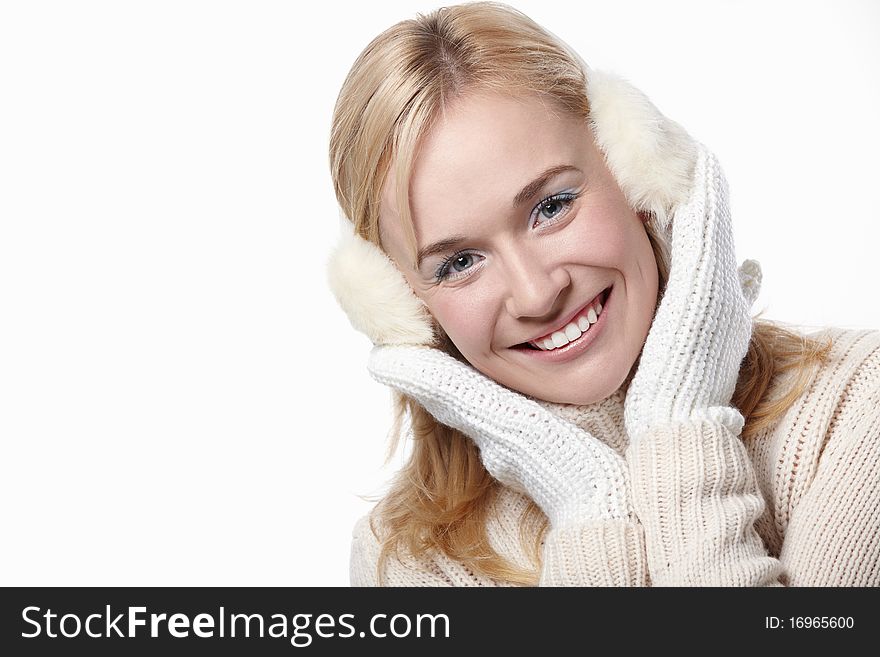 Young girl in mittens and headphones on a white background. Young girl in mittens and headphones on a white background