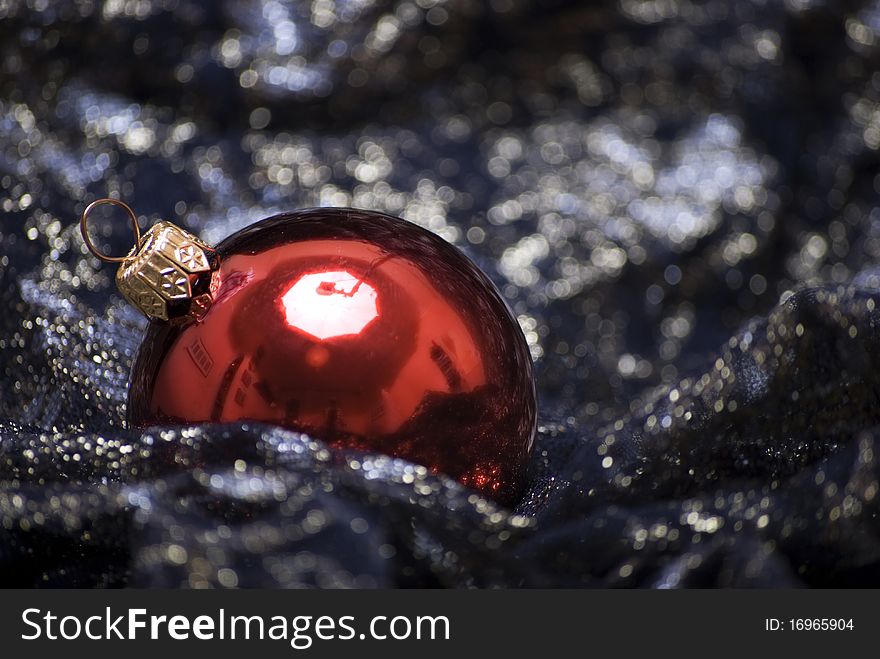 Red Christmas ball on the sheer black material. Red Christmas ball on the sheer black material