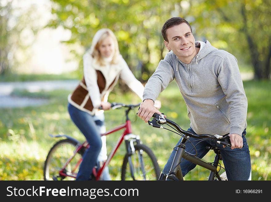 A man on a bicycle in the park in the foreground. A man on a bicycle in the park in the foreground