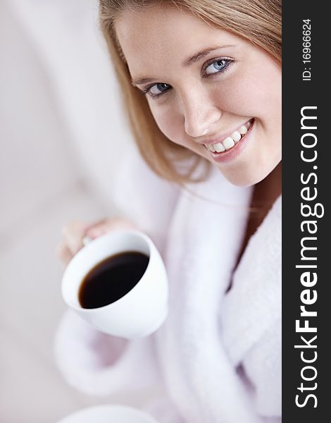 An attractive young woman holding a cup of coffee. An attractive young woman holding a cup of coffee
