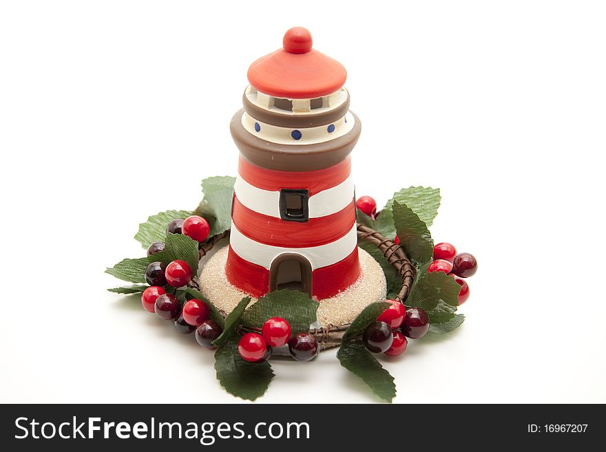 Ceramics lighthouse in the wreath with berries