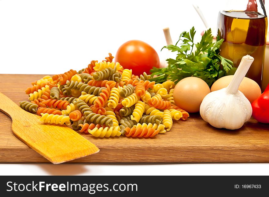 Close-up shot of spaghetti and vegetables on wooden board. Isolated on white