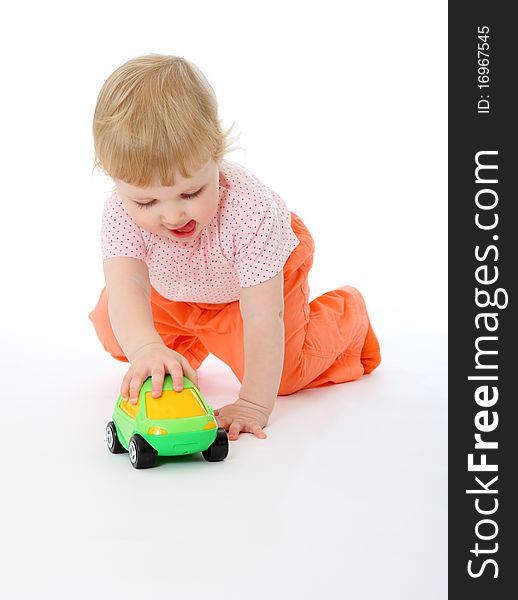 Studio portrait of 1 year old baby playing with a toy car on white background