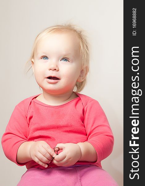 Portrait of cute young baby sit on chair and grimacing