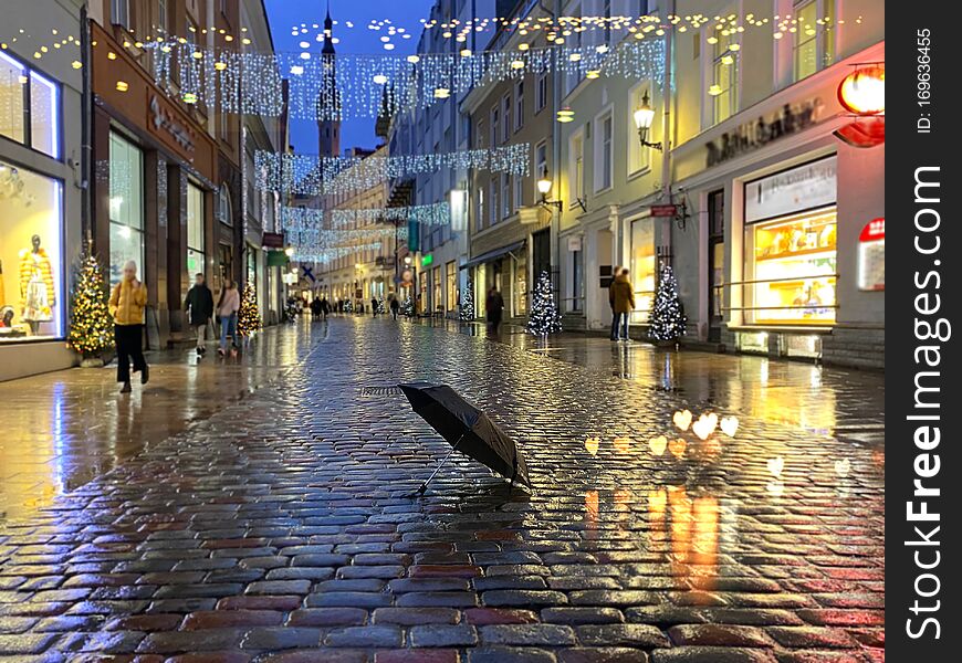 Rainy  City Christmas Tallinn Old town street night  light people walking with umbrellas rain drops reflection on window