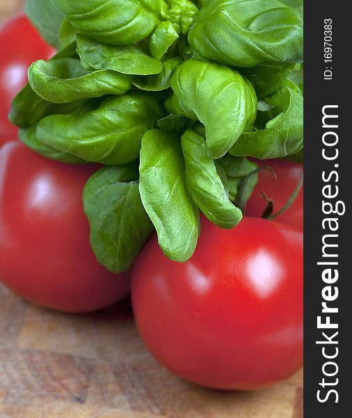 Basil and tomatoes on a wooden board. Basil and tomatoes on a wooden board