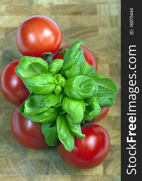 Basil and tomatoes on a wooden  board. Basil and tomatoes on a wooden  board