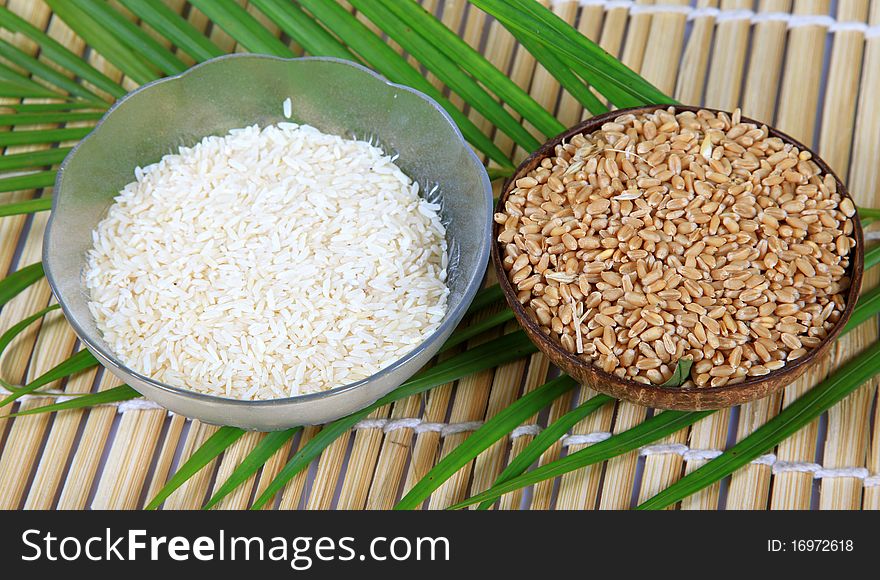 Wheat and rice bowls over wooden background.