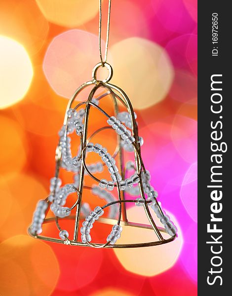 Christmas bell with silver beads against blurred background. Christmas bell with silver beads against blurred background