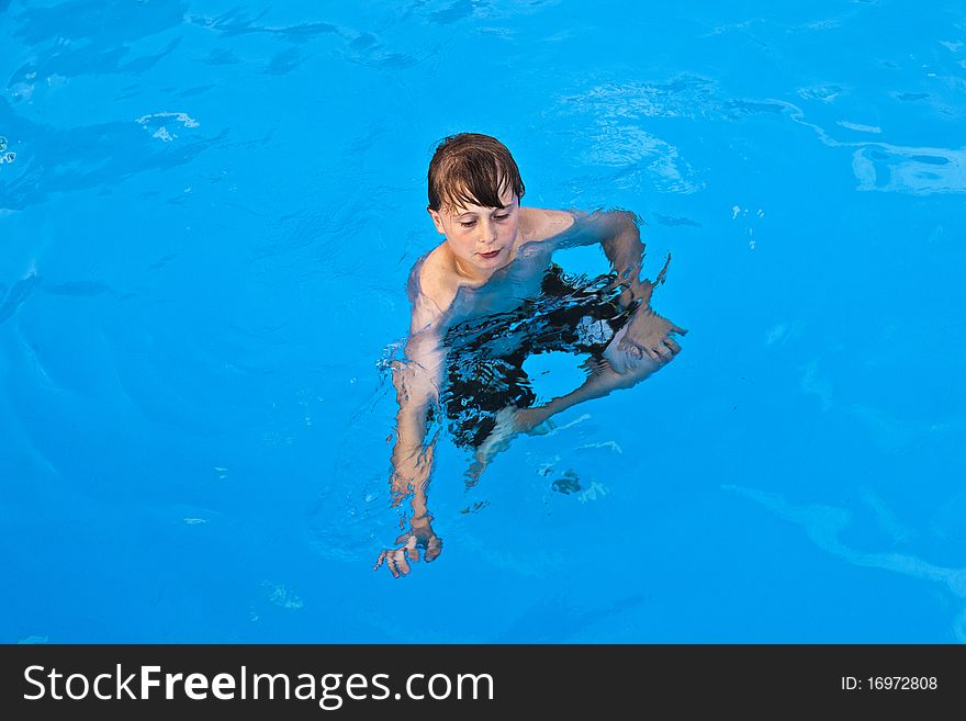 Boy Has Fun Swimming In The Pool