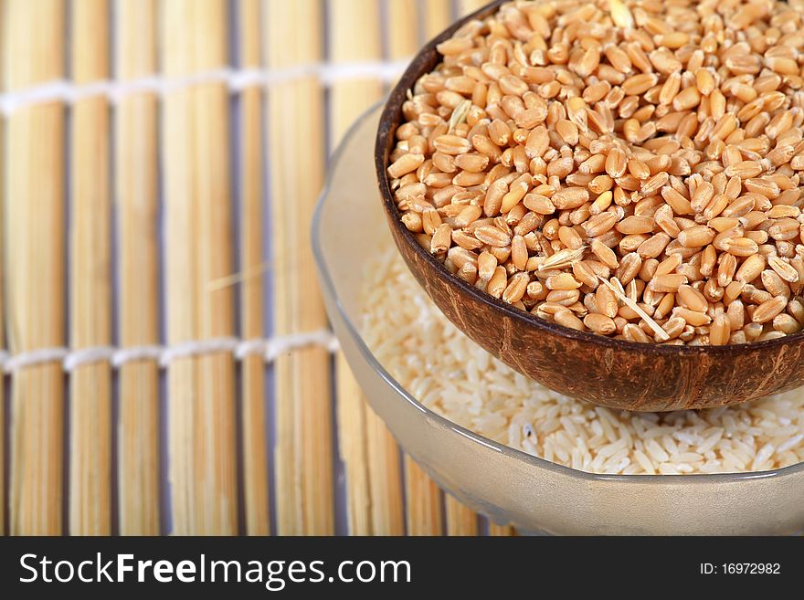 Wheat and rice bowls over wooden background.