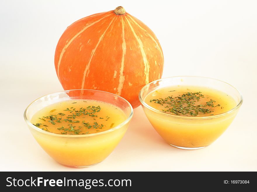 Two bowls of pumpkin soup and pumpkin in Thanksgiving Day or Halloween. Two bowls of pumpkin soup and pumpkin in Thanksgiving Day or Halloween