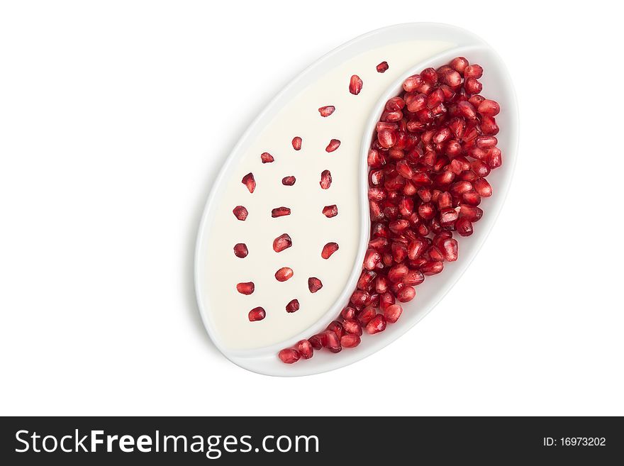Plate with peeled ripe seeds pomegranate and cream isolated