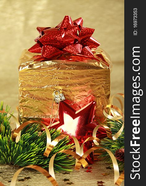Golden christmas gift box with red bow and star