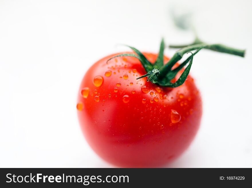 Fresh red tomato with water drops. Isolated on white background