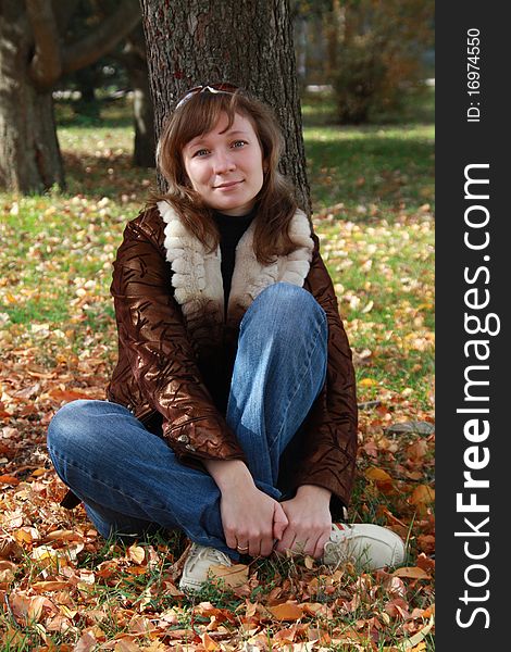 Girl Sits In Autumn Park