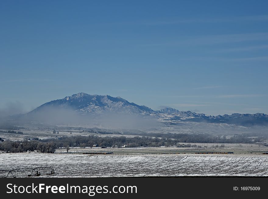 Rocky mountains in wyoming with a fog bank and a field. Rocky mountains in wyoming with a fog bank and a field.