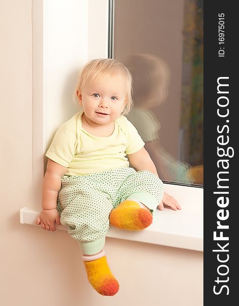 Adorable Toddler Girl Sitting On The Window Sill