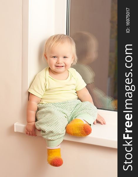 Adorable Girl Sitting On The Window Sill