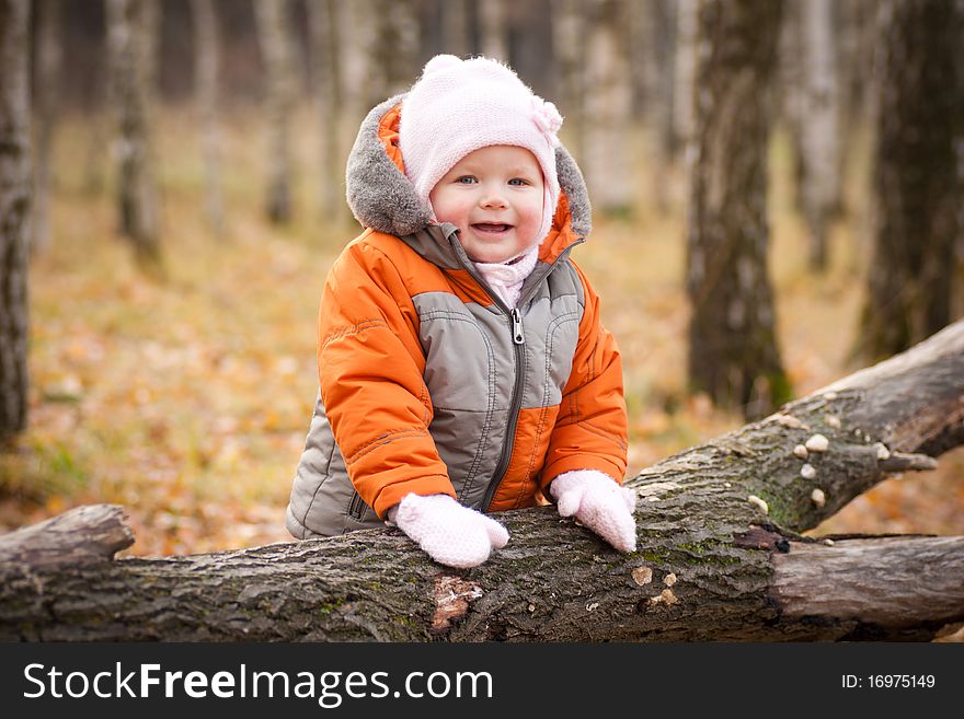 Cute adorable baby smile and stay near fallen tree. Cute adorable baby smile and stay near fallen tree