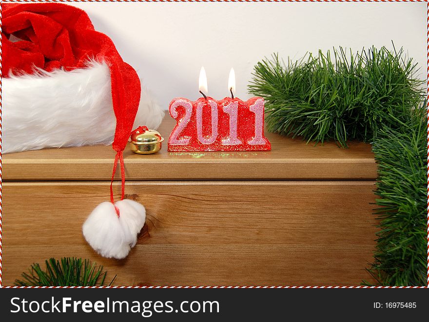 2011 candles isolated on wooden table,with tree branch and Santa hat. 2011 candles isolated on wooden table,with tree branch and Santa hat